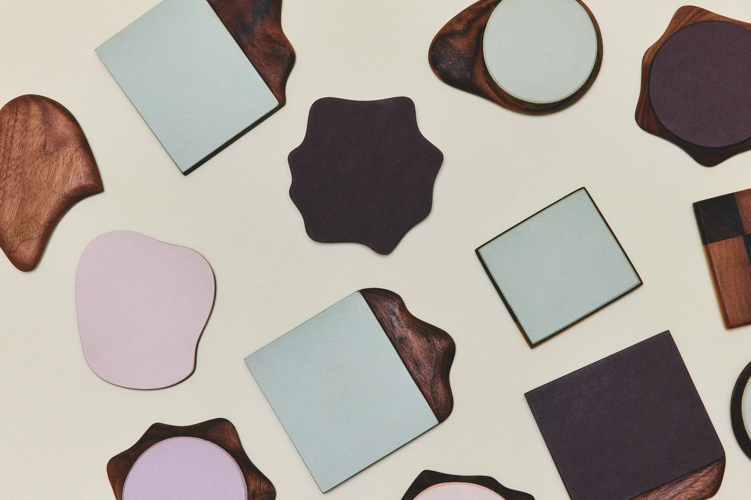 A flat lay of various mirror and tabletop accessories with different shapes and wood materials, arranged on a white background.