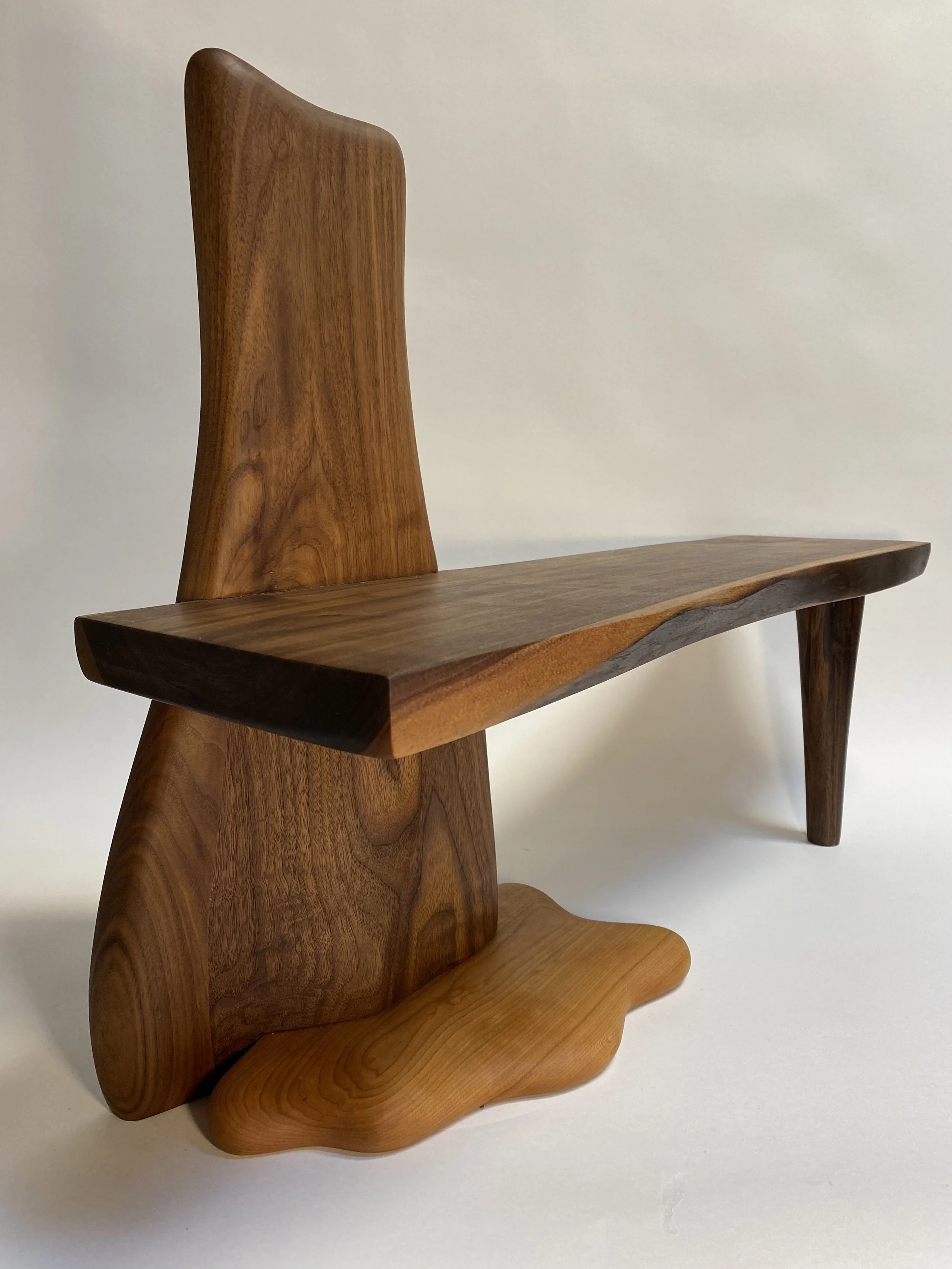 A wooden chair with a high backrest, a flat seat, and angled legs.