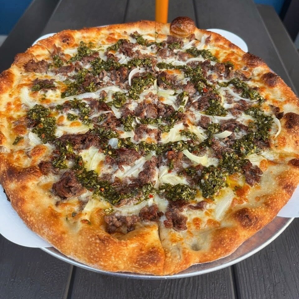 Light up your taste buds with our newest hero, The Green Lantern special! 🟢

Our pizza pros have created a flavor adventure featuring garlic parm oil base, shredded ribeye, onions, and chimichurri.

Get your fix - 14&rdquo; for $23 or level up to an
