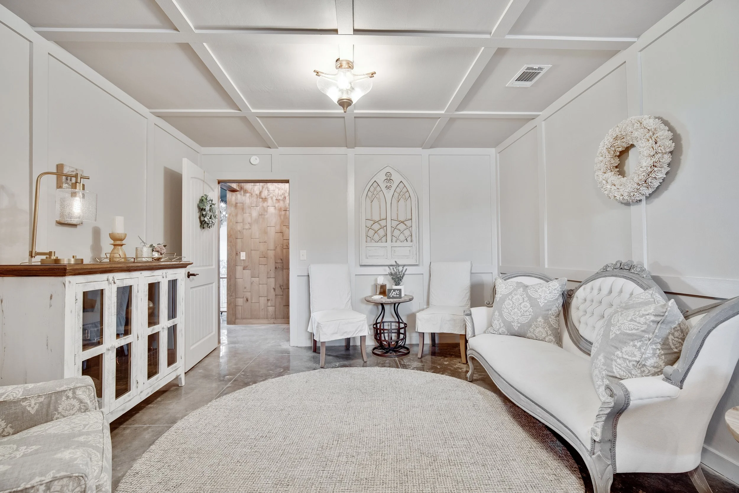 Large bridal suite with ample space, white walls, plenty of lighting is a backdrop for beautiful getting-ready portraits.