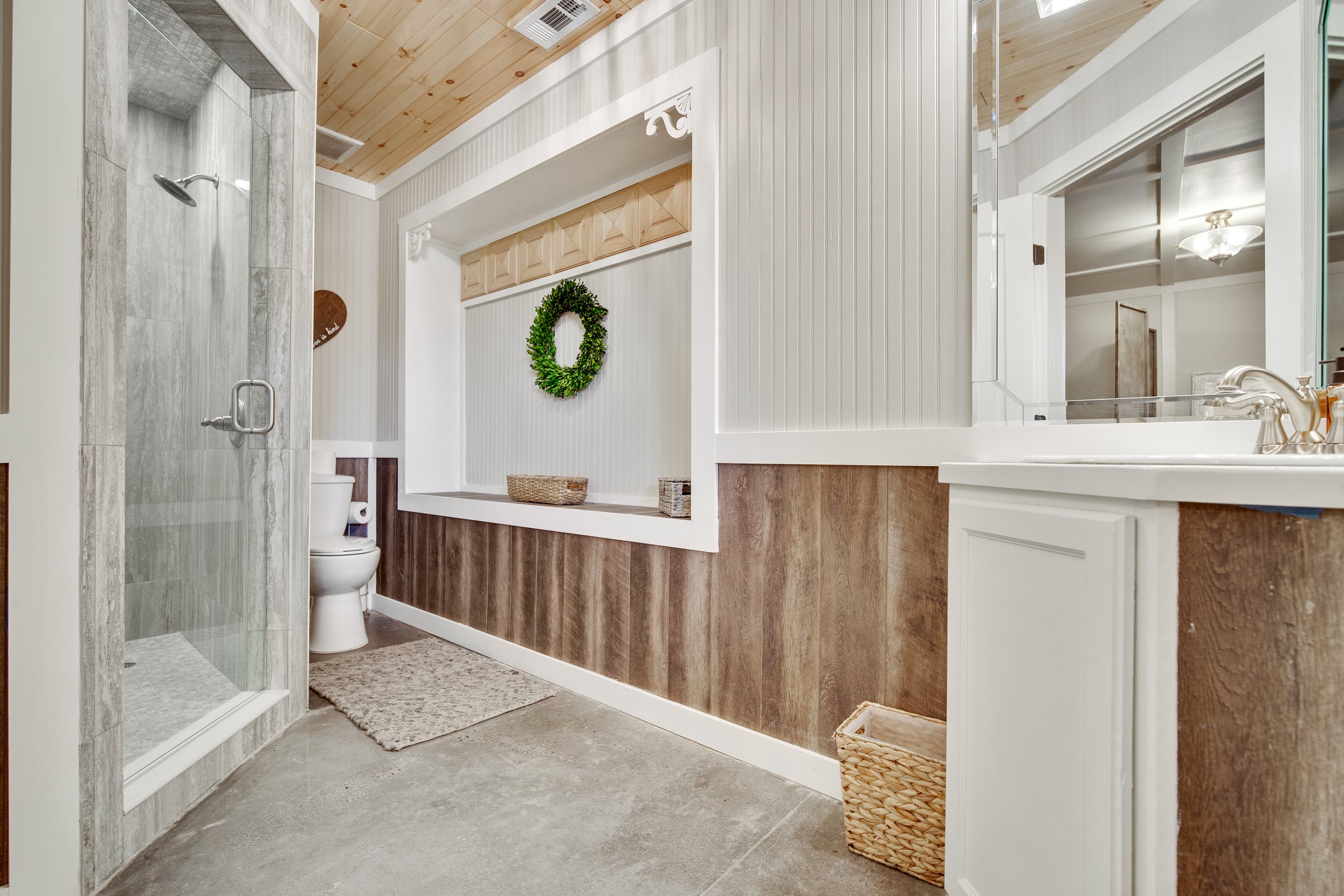 Ocoee Crest wedding venue bridal suite includes a luxury shower and sink. Bright lights, white paint, and wood accents.