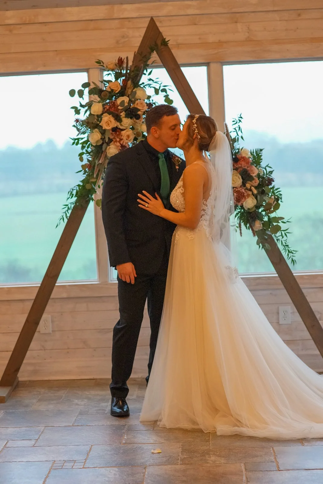 Married couple kiss at intimate wedding venue with a view of the mountains near Chattanooga, TN. Indoor rain plan option.