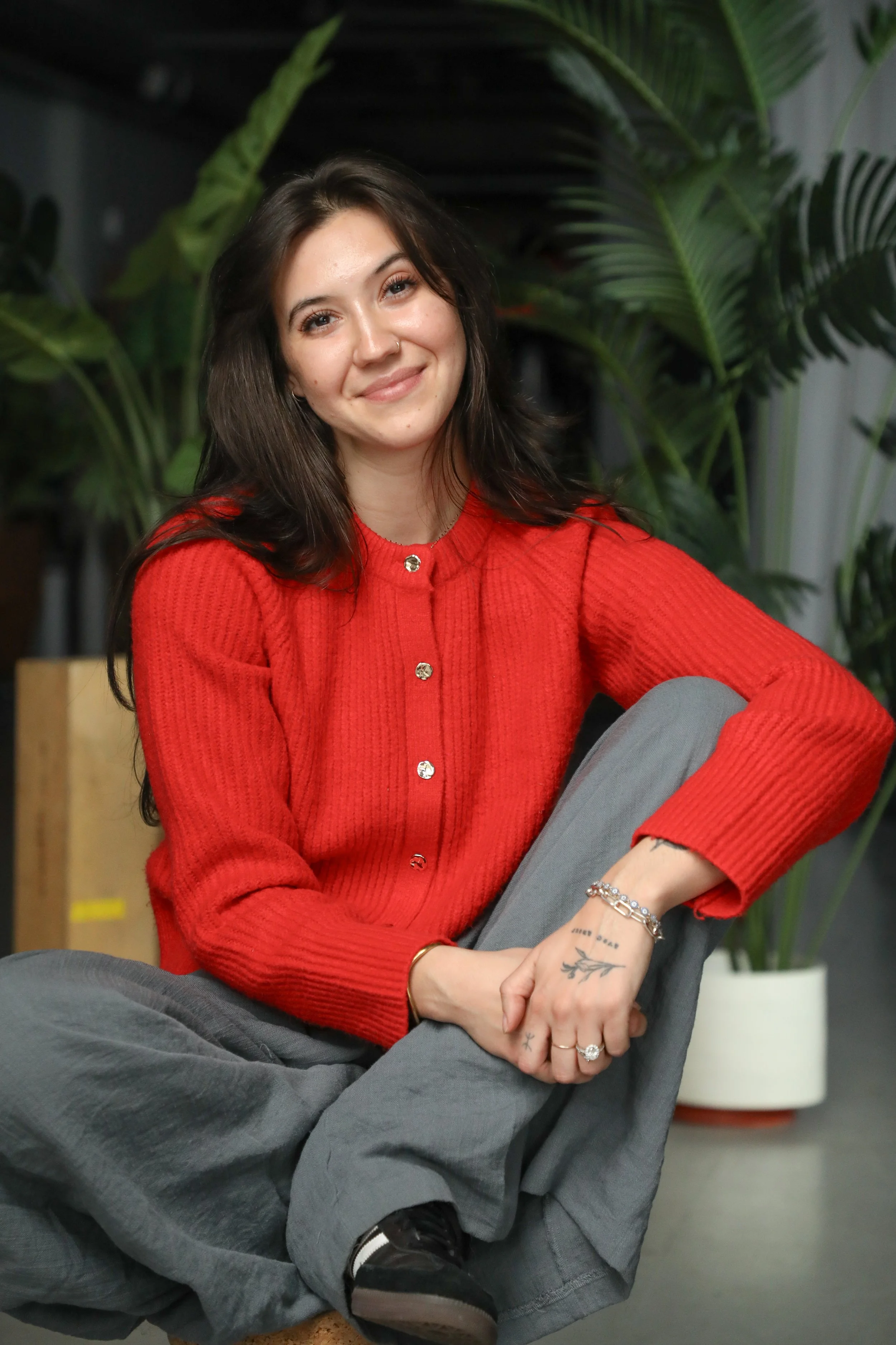 Headshot of therapist Neila Ouldali wearing a red sweater and sitting casually smiling at camera.