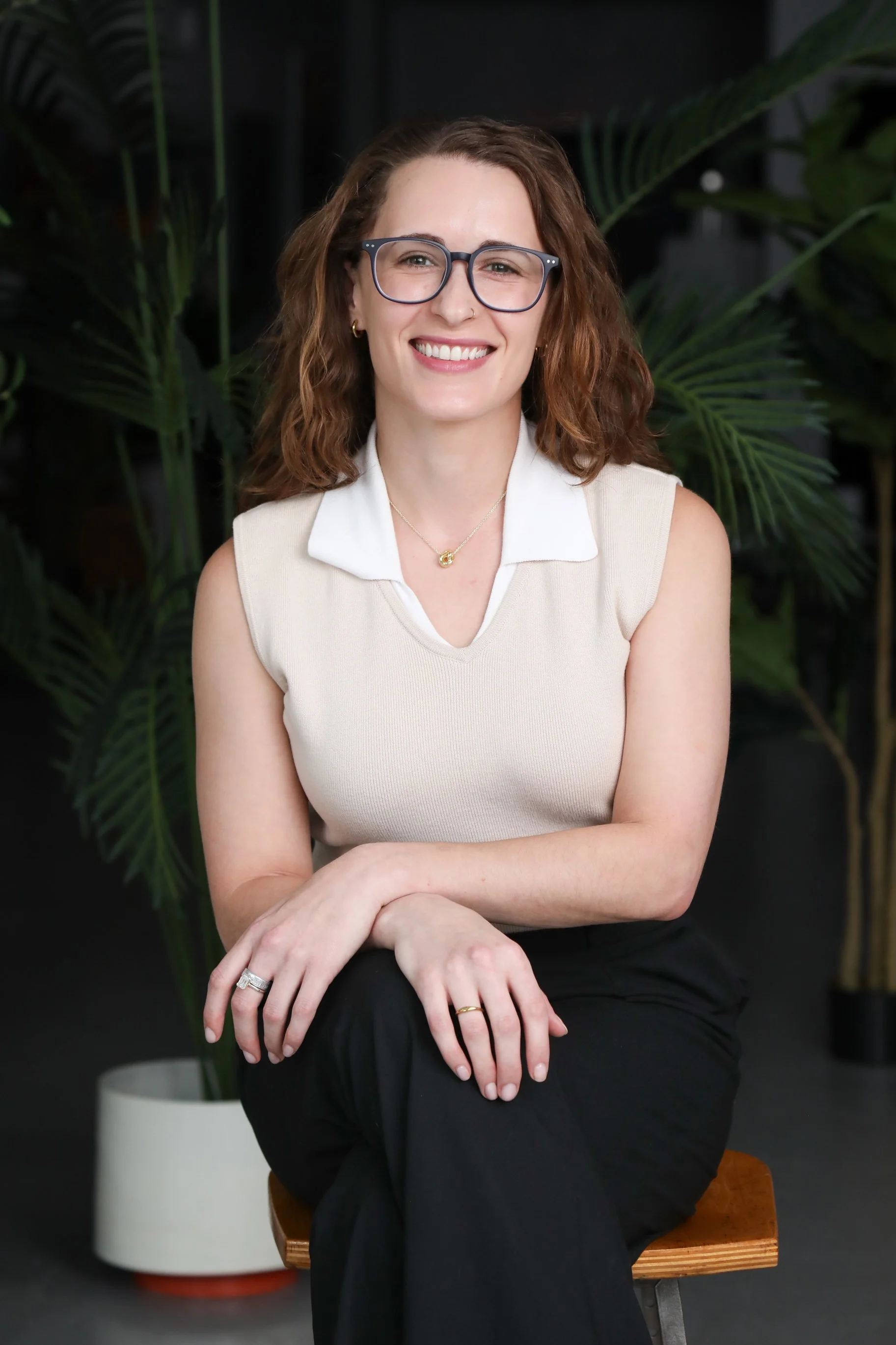 Headshot of therapist Gabriella Bova wearing white top and glasses smiling at the viewer
