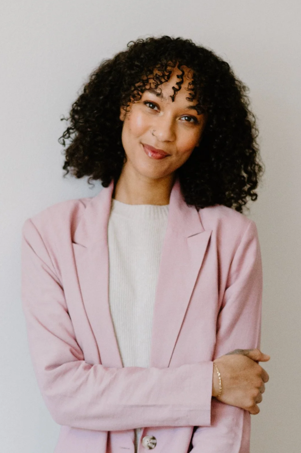 Headshot of therapist Aminah in pink blazer and white shirt.