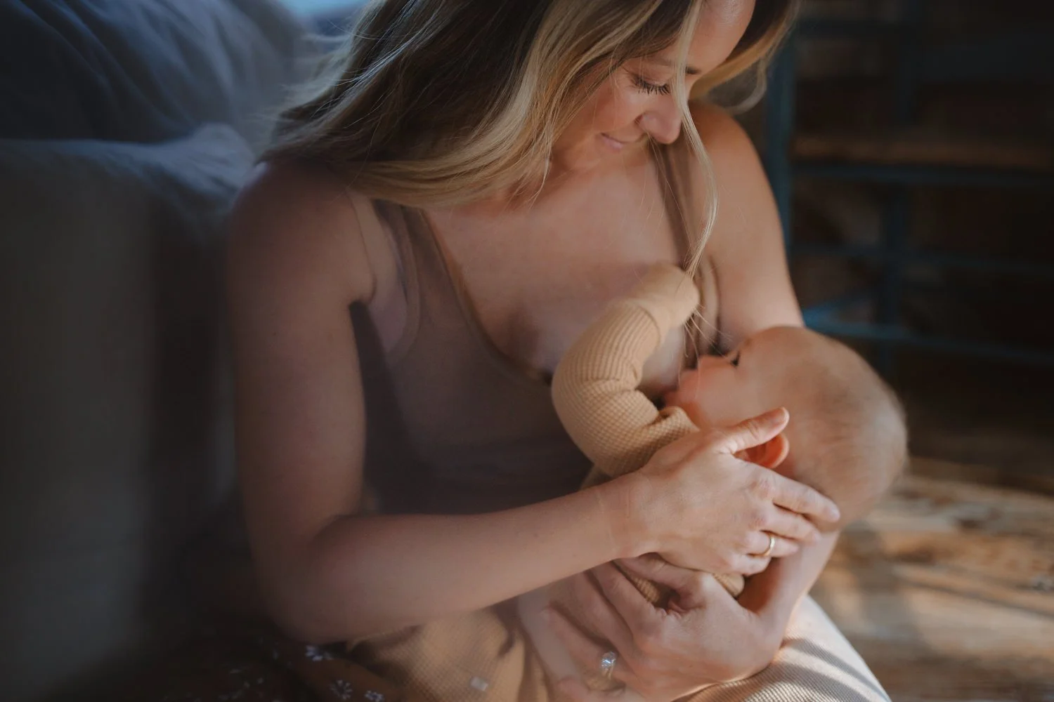 Mother nursing her newborn in soft indoor light, captured by a newborn photographer in New York