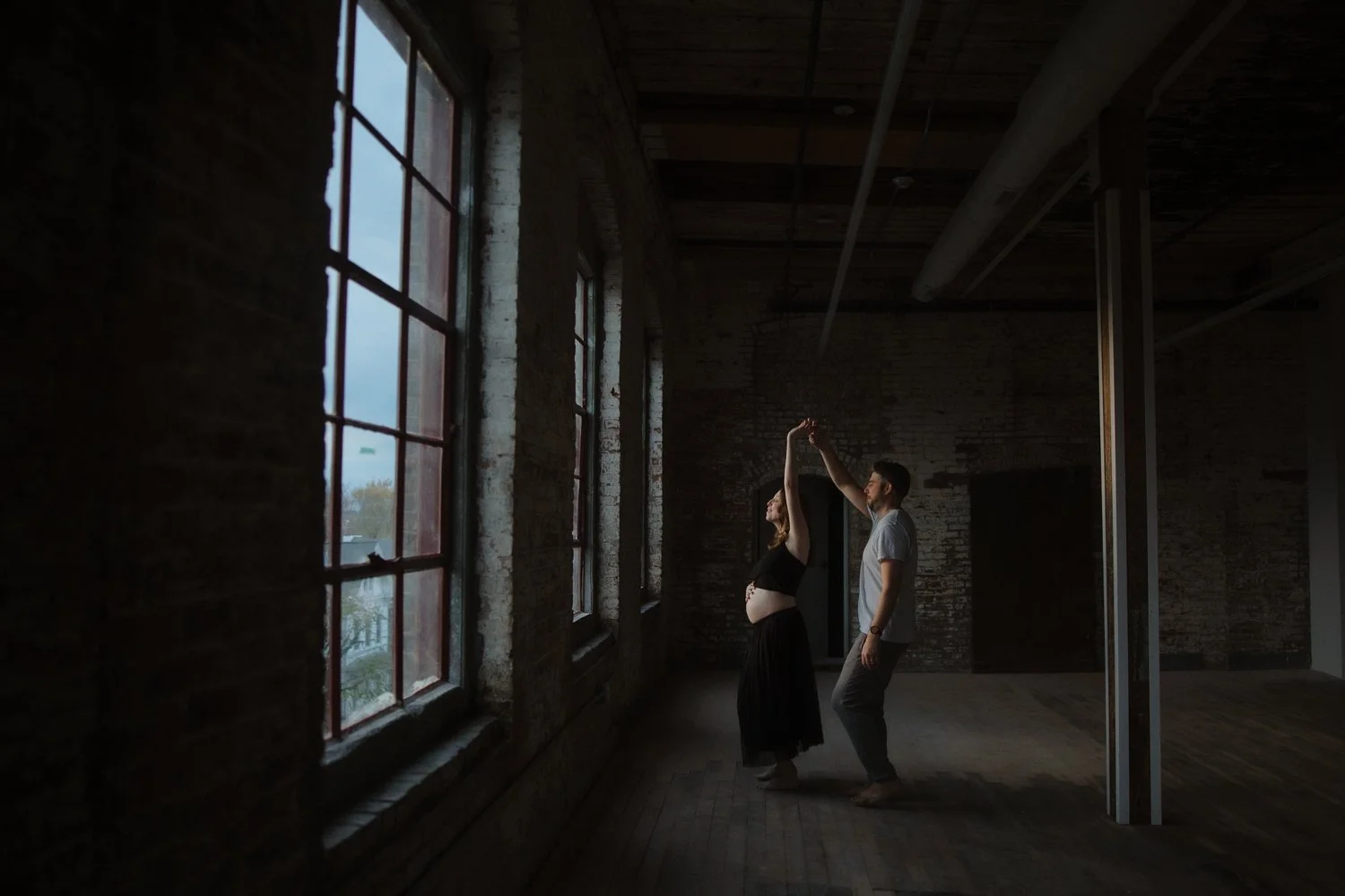 Empty industrial loft with exposed brick walls and large windows