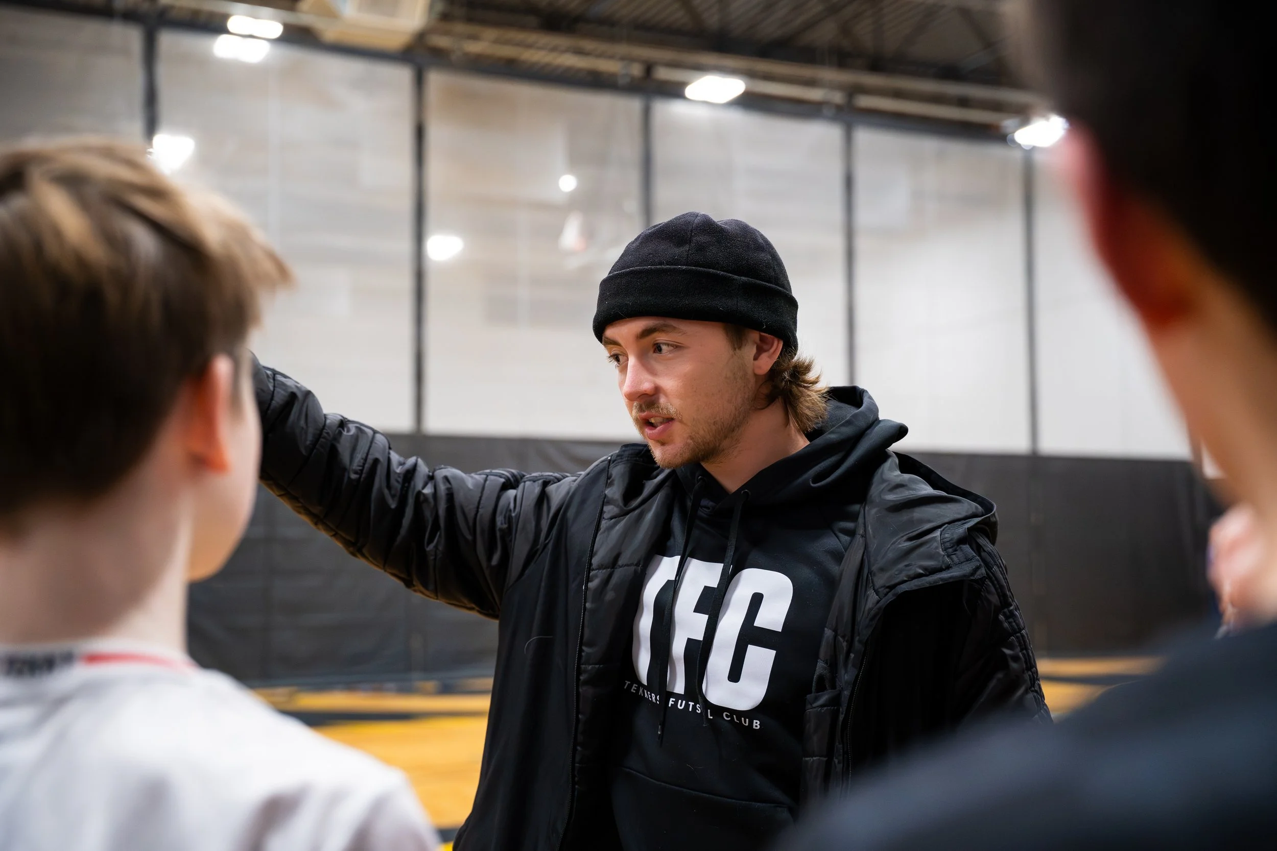 Group of young men in white soccer uniforms celebrating on a soccer field