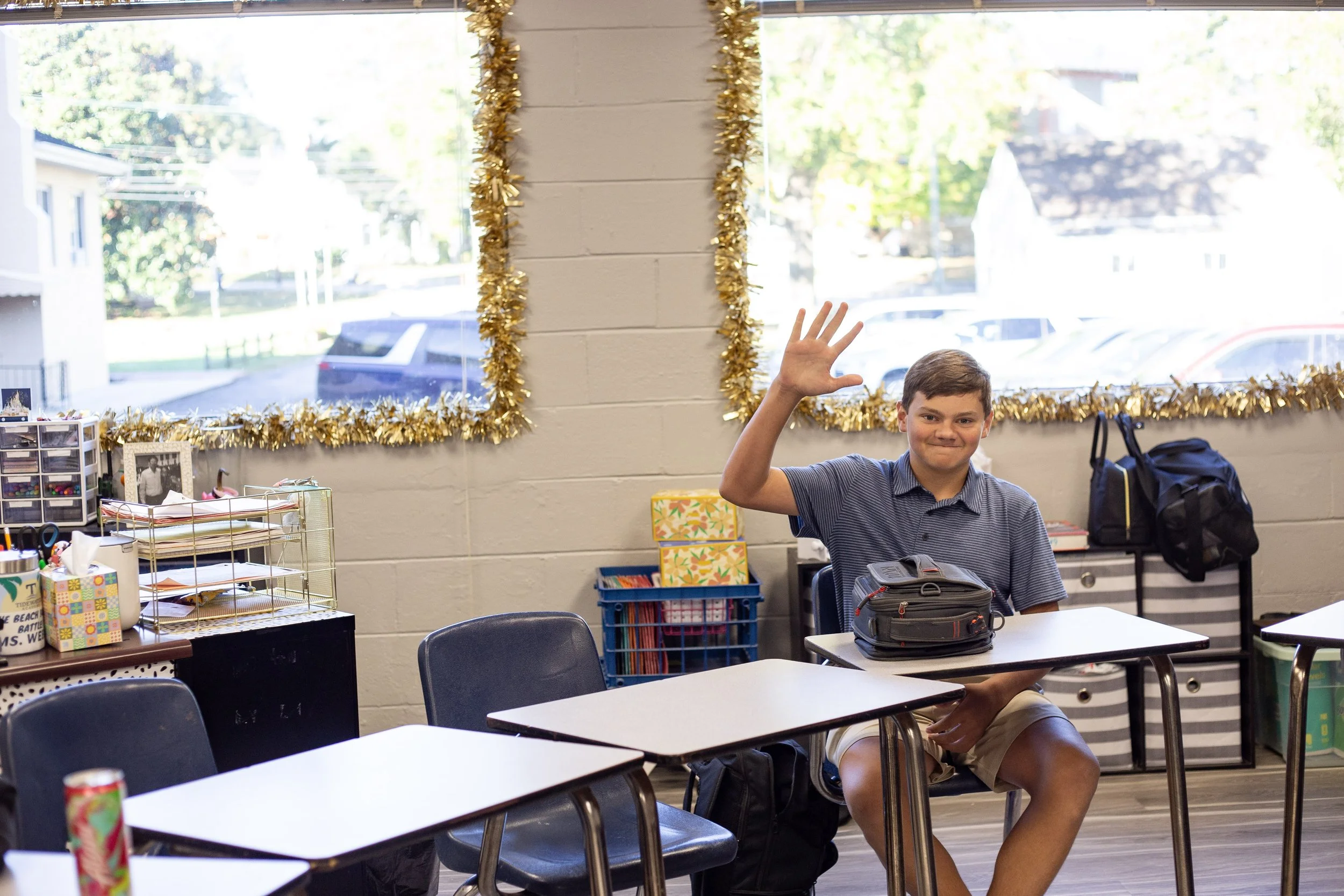 Group of graduates in caps and gowns standing in front of brick building with stained glass window.