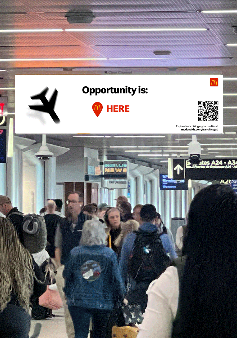 Travelers walking through an airport terminal beneath a McDonald's franchise billboard reading 'Opportunity is HERE