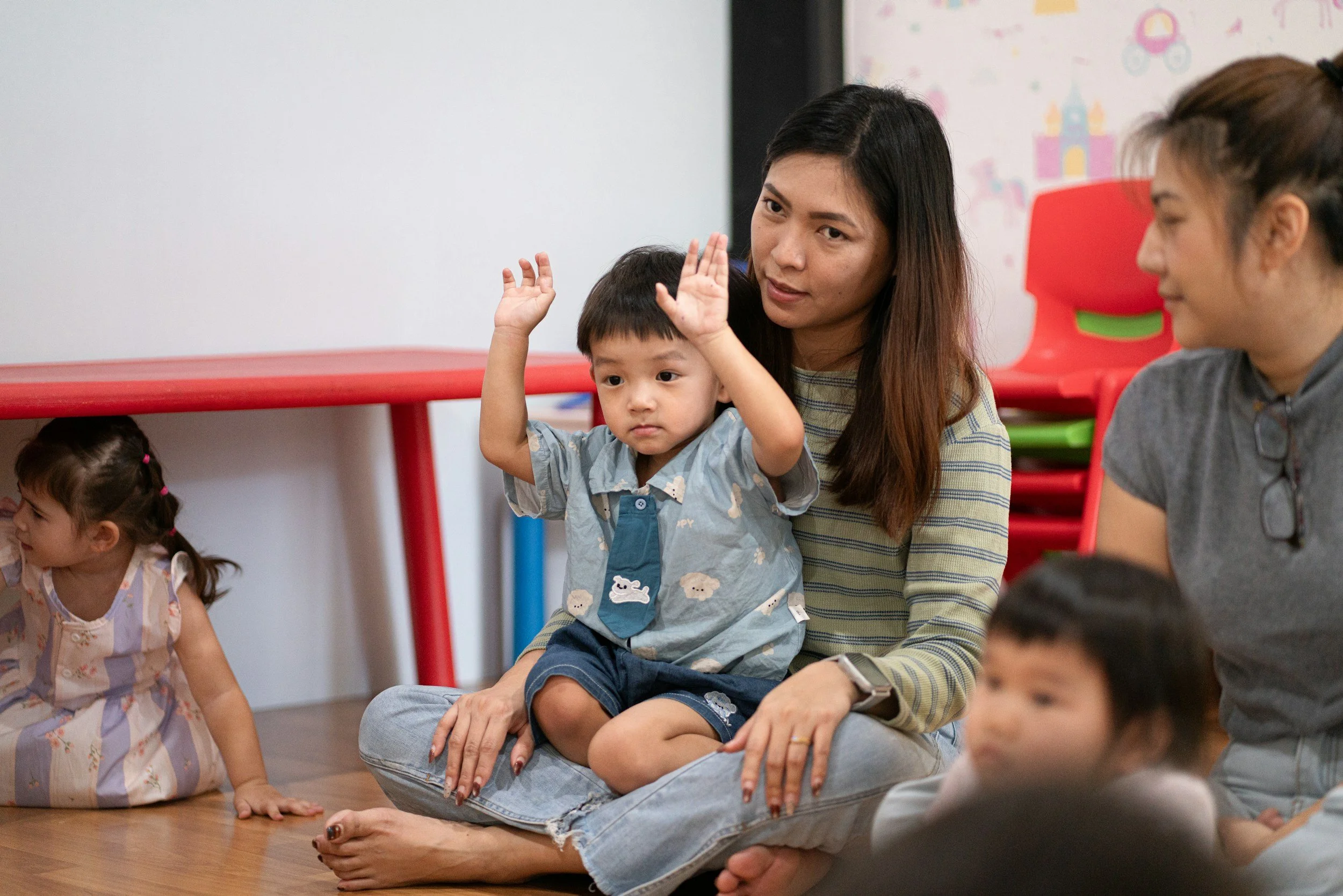 Childcare provider with young children in a classroom setting
