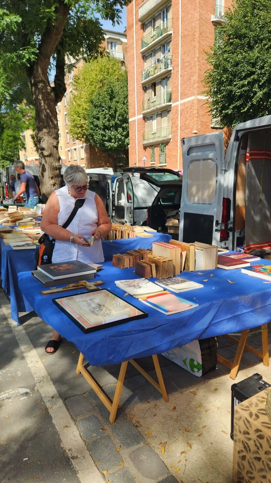 The author browsing a book table at a French flea market.
