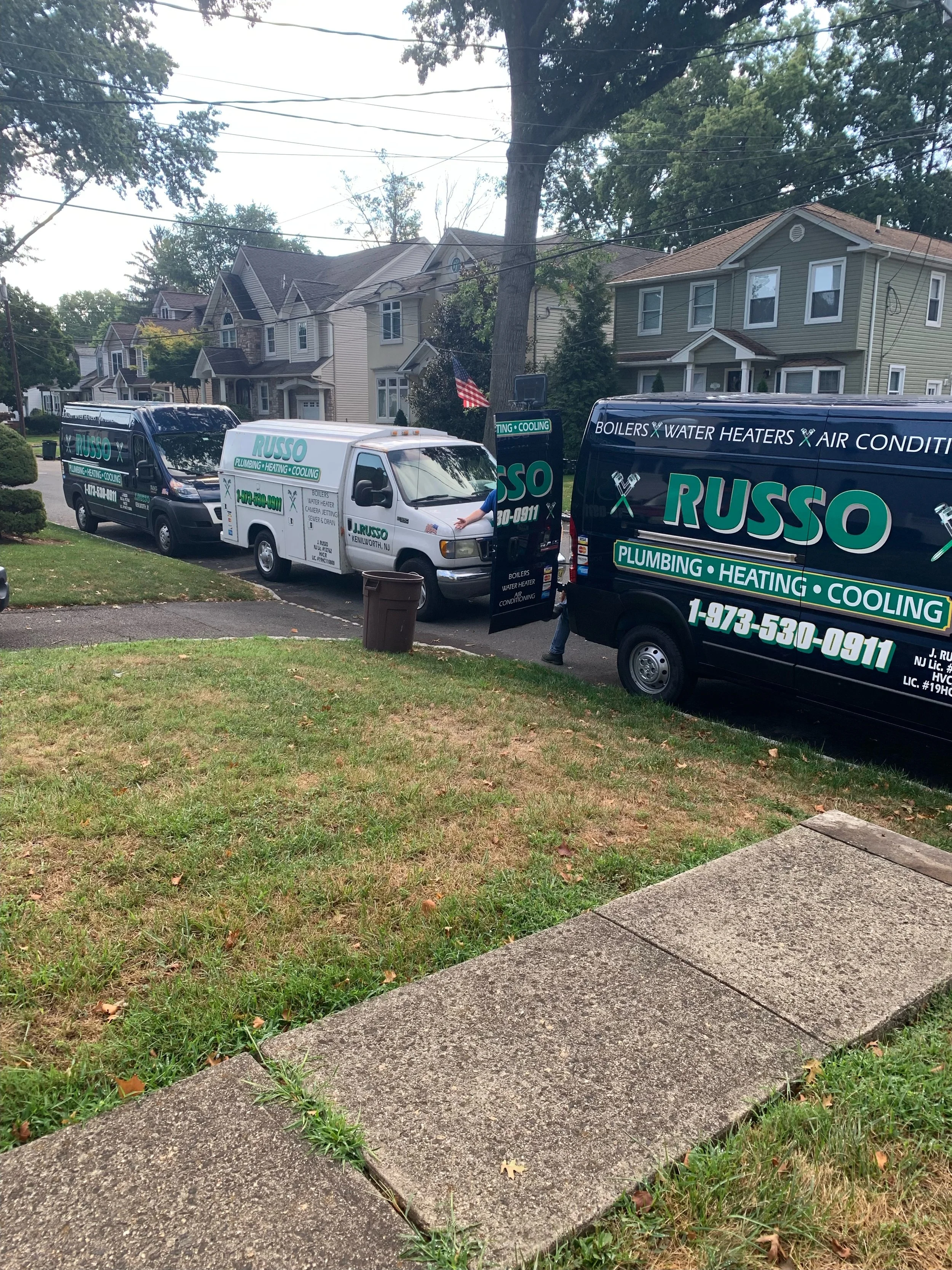 3 branded work vans parked in front of a client's home