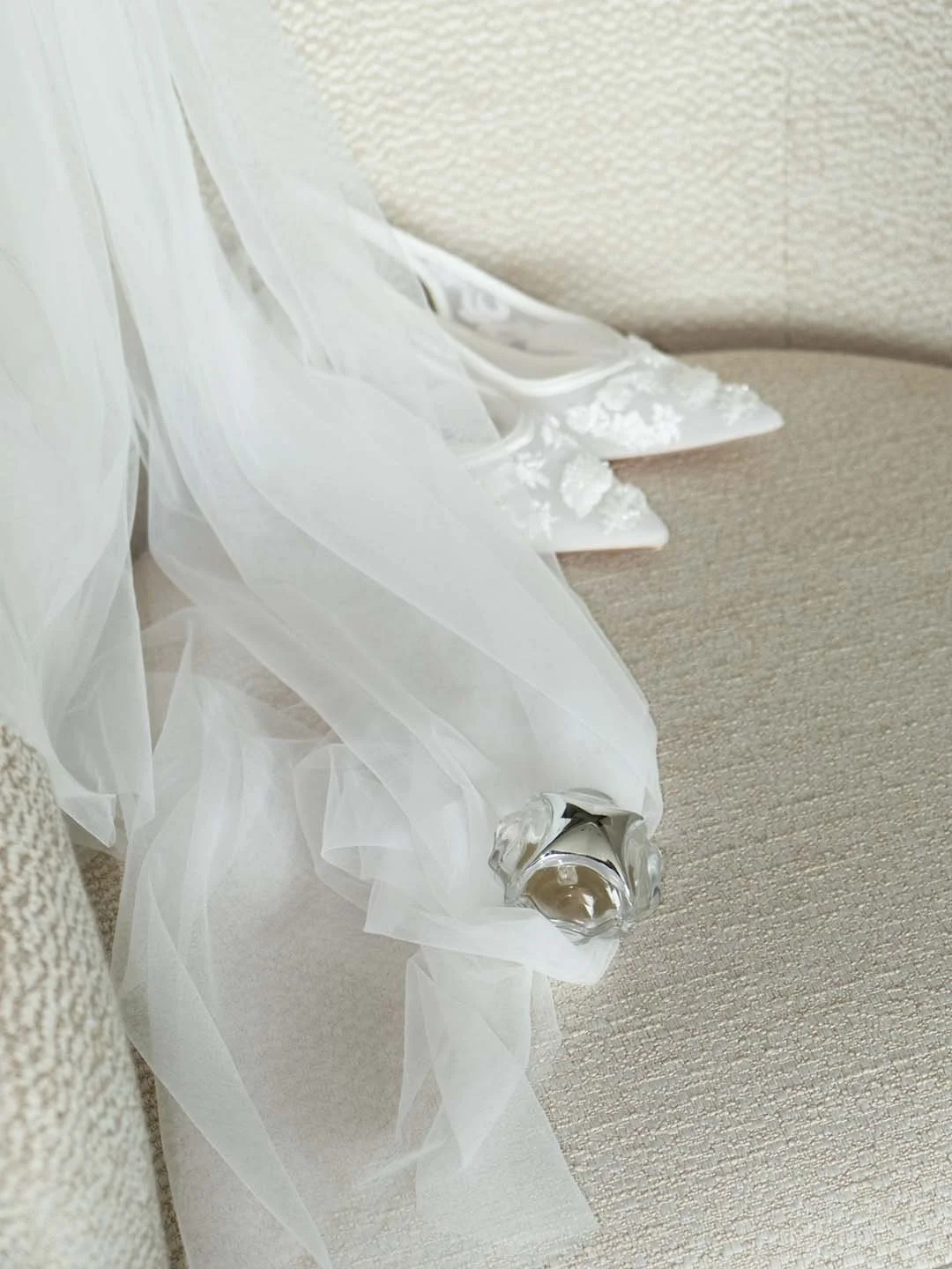 Nova of Dream Ring box putting on a white wedding dress with a pair of white high heels on a beige sofa