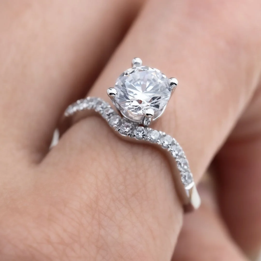 A hand wearing a Born to meet diamond ring