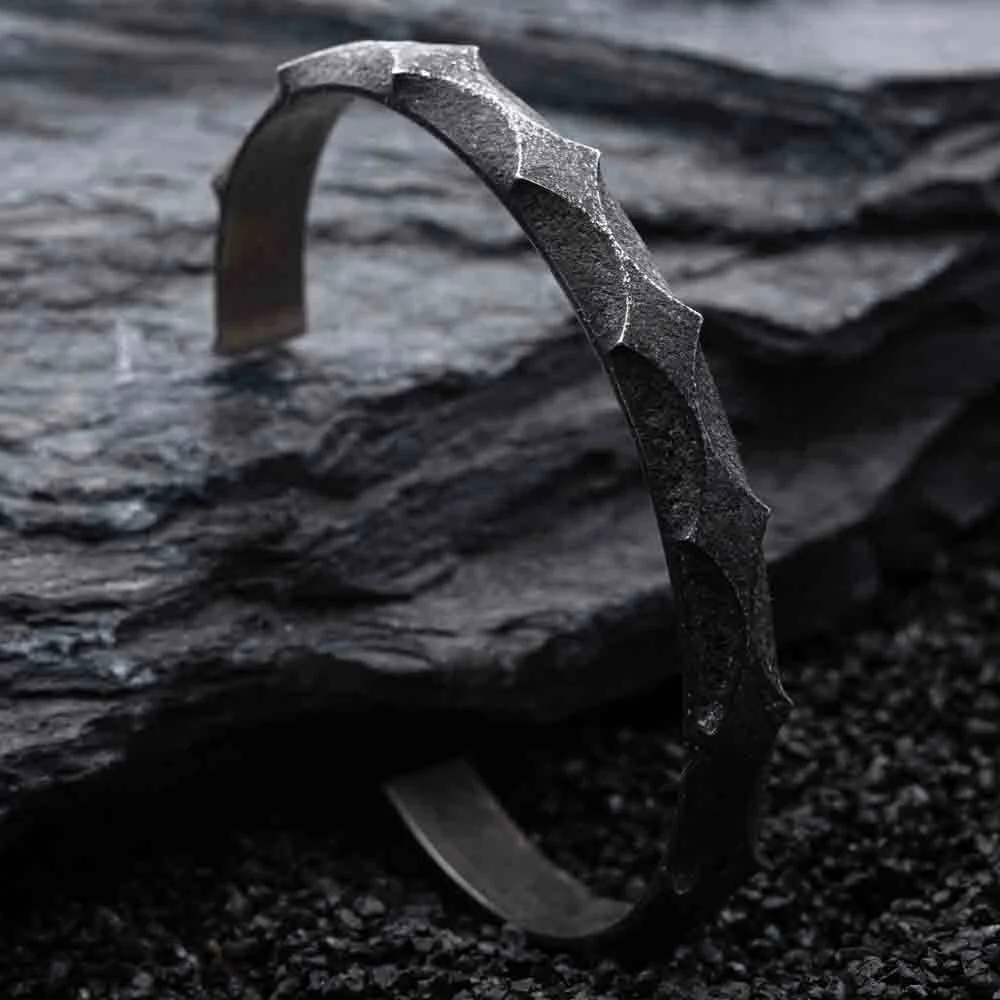 Close-up of 2073 City Decay lost star 05 Bracelet in star shape on black rock and sand