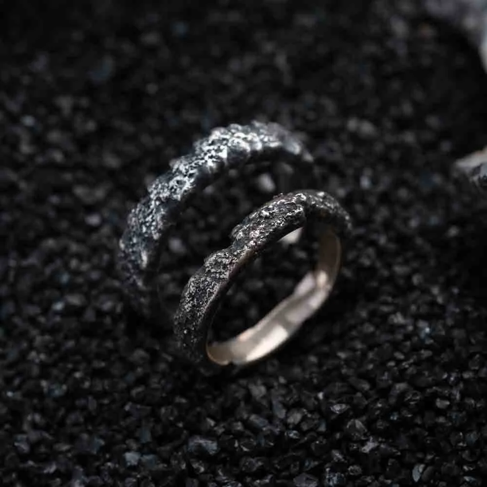 Two 2073 City Decay Stardust Ring with raw texture on black sand