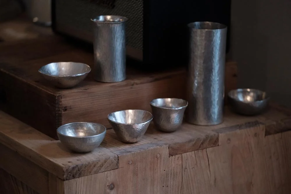 forging pure tin material sake cup and vase on a wooden cupboard