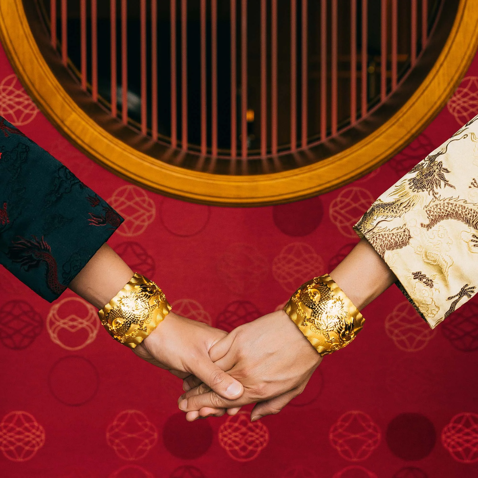a couple wearing traditional chinese gown holding each other hands wearing the collection of the Proud Pair in yellow gold