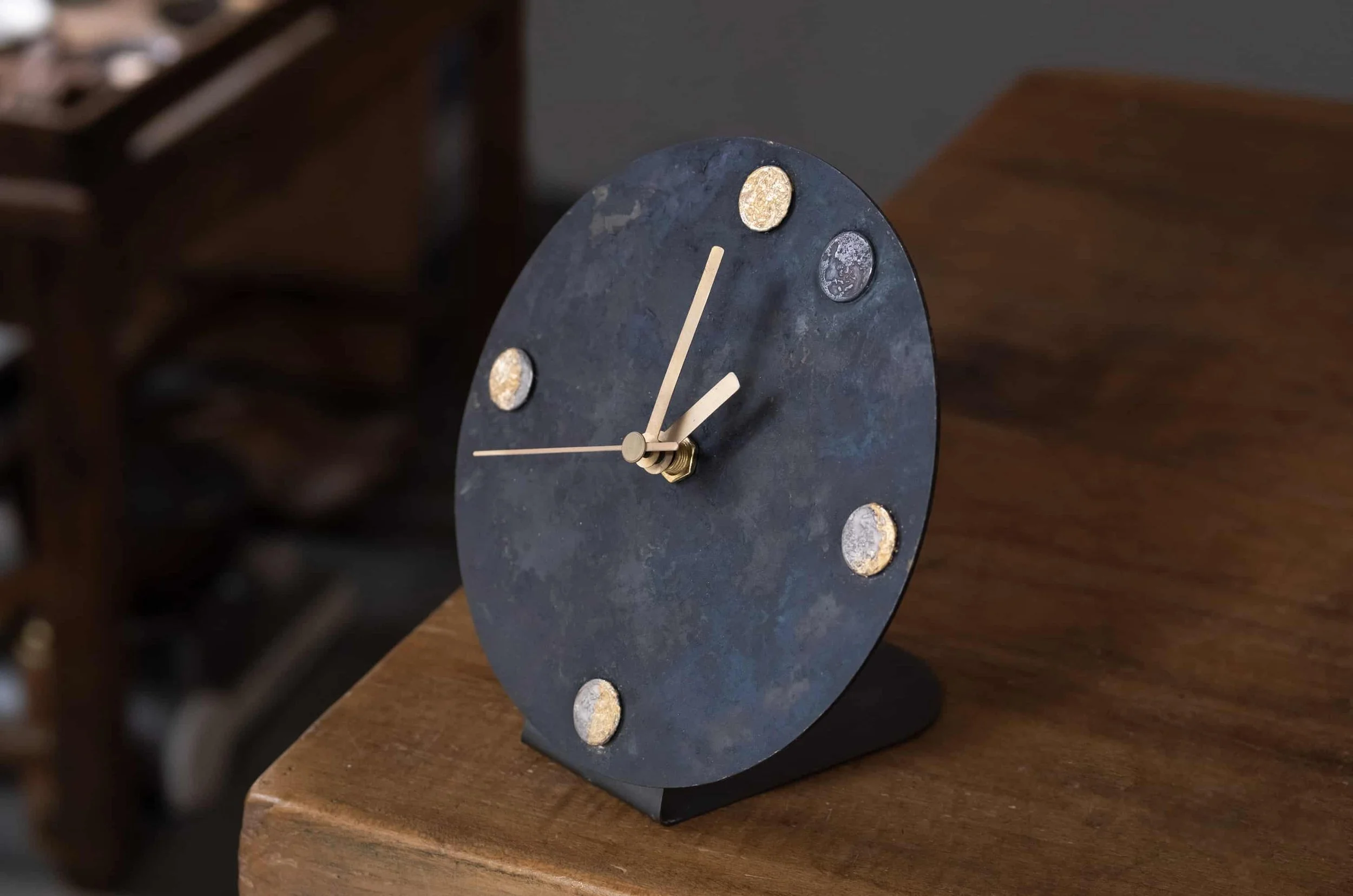 Redesigned artwork a moon shape desk clock from the moon necklace on a wooden table