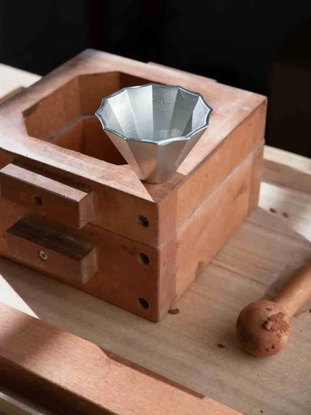 A pure tin sake cap on a wooden casting model