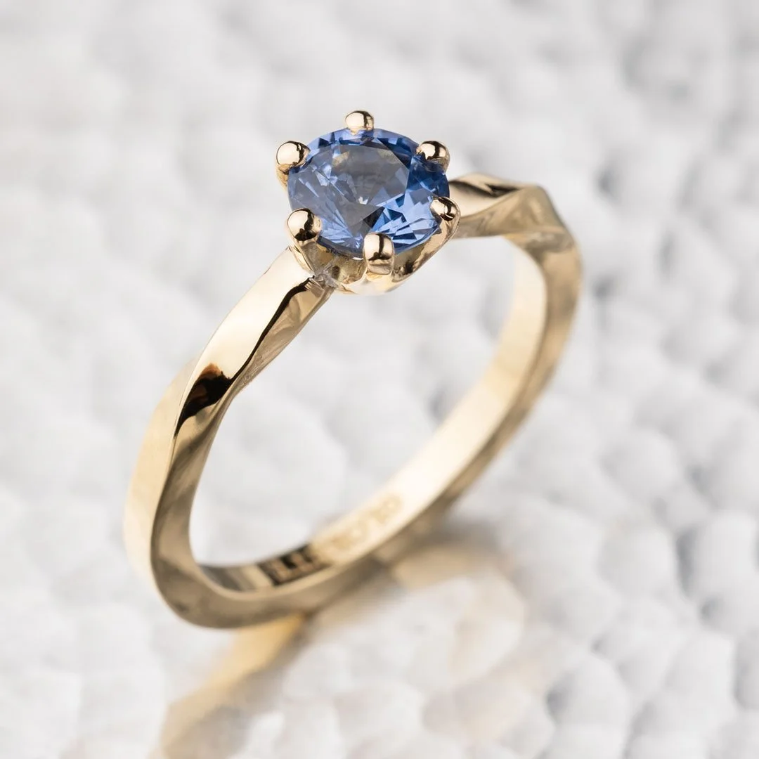 infinity sapphire 200% blue diamond ring placed on a sliver surface