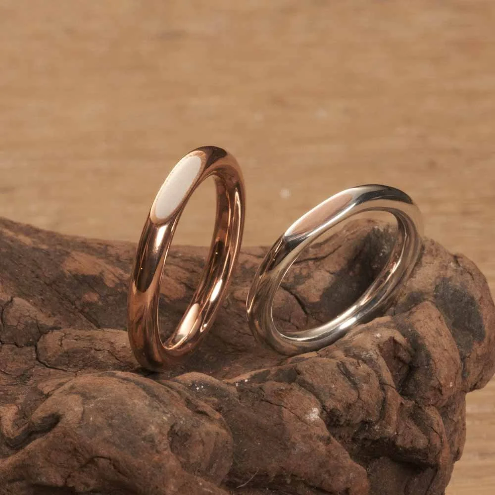 Close-up of two Driftwood Rings with copper and silver material