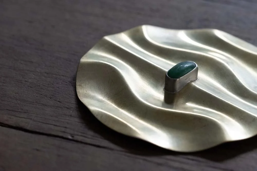 A final recreation of Father's Relic turn into a gold plate with part of the relic and green gem stone in the middle of the plate
