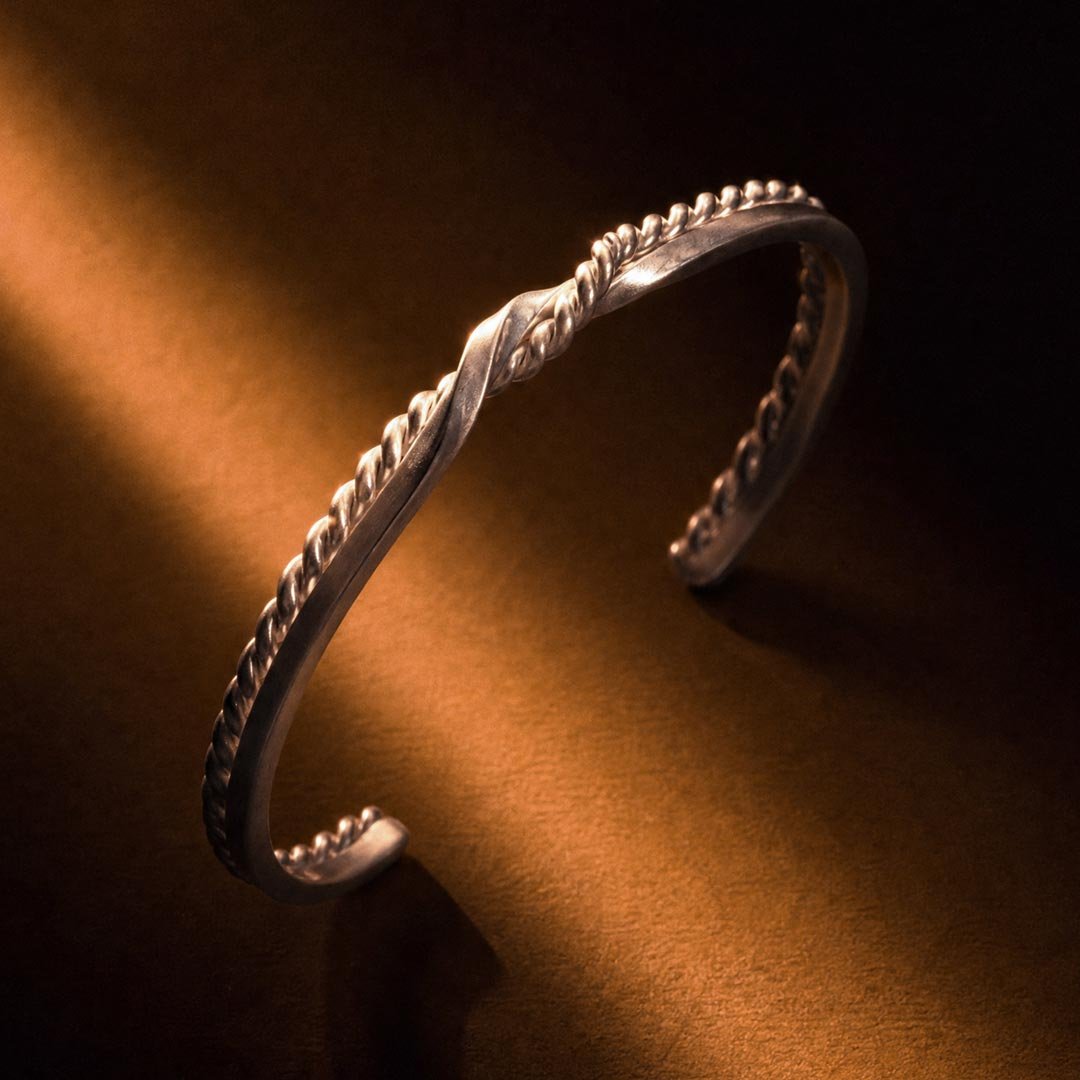 Close-up of silver Twin Souls Promise bracelet on a silver surface