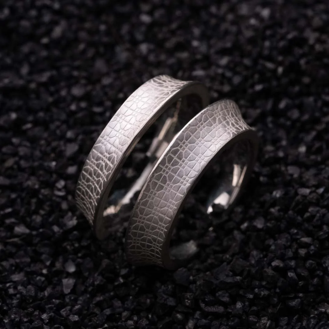 Silver ring from the 2073 City Decay collection placed on black sand