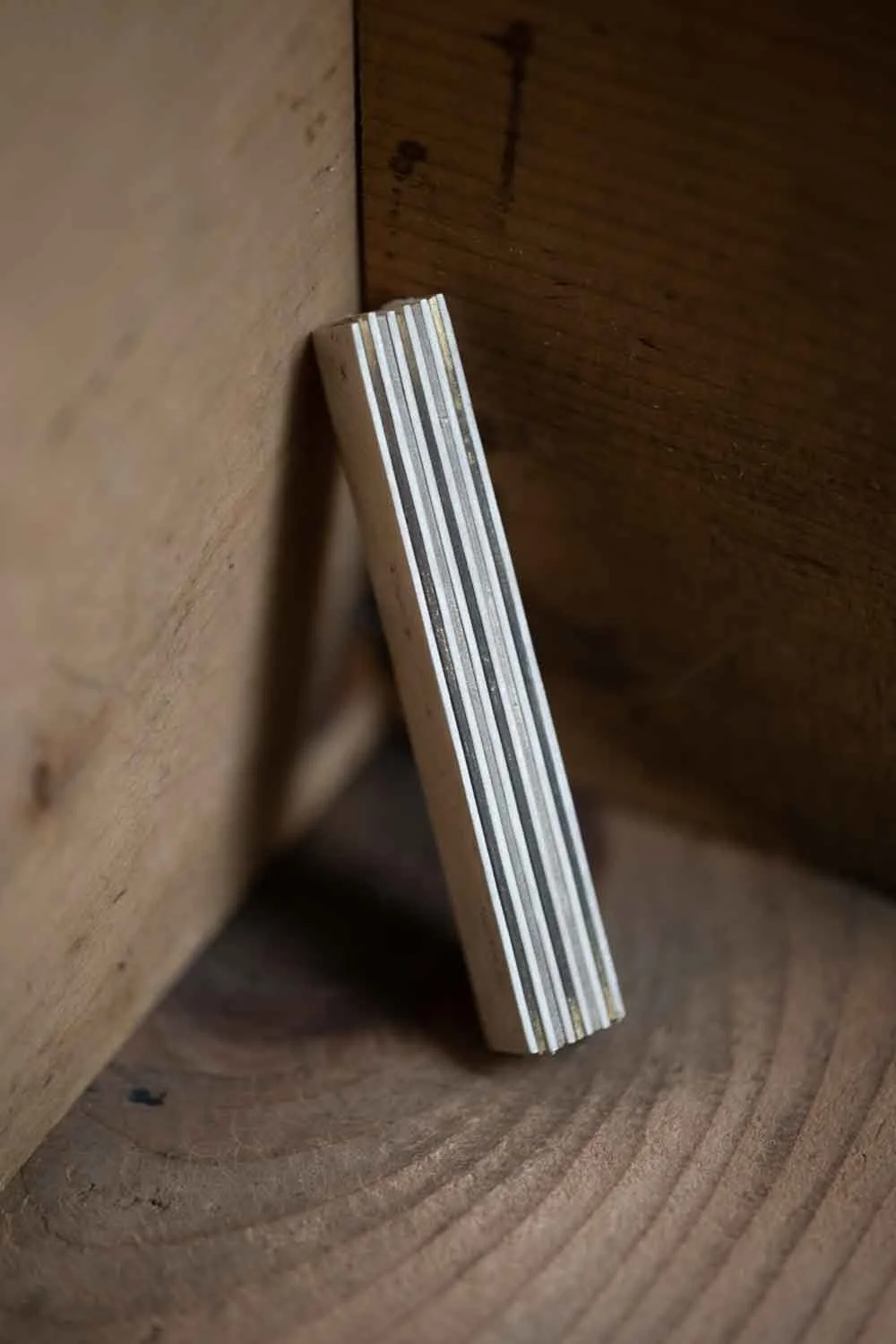 Material of Perfectly Imperfect collection Gold Version placed next to the corner of the wooden wall