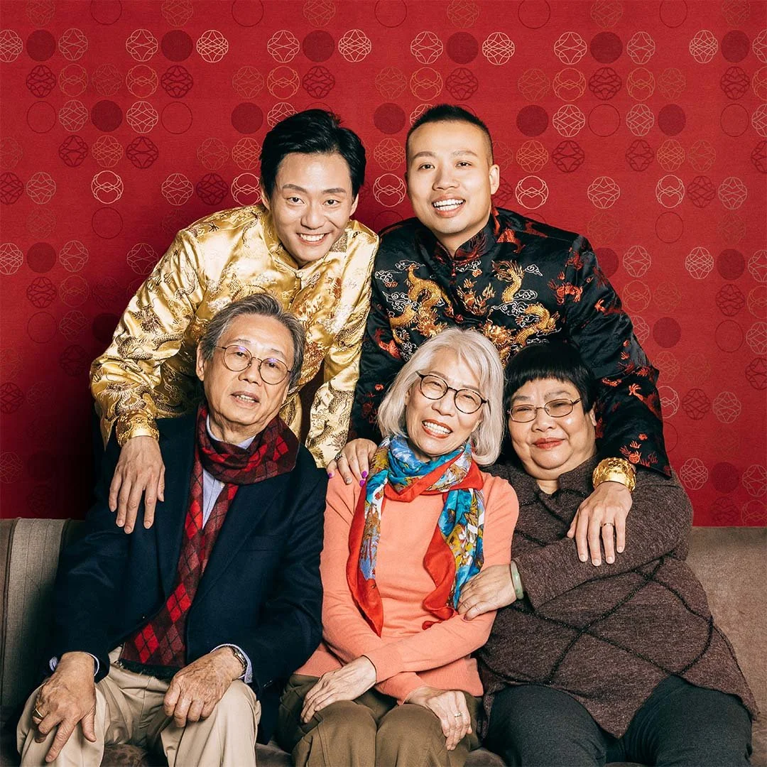 Family photo taken under the red pattern cloth, a gay couple wearing The Proud Pair collection on their hands