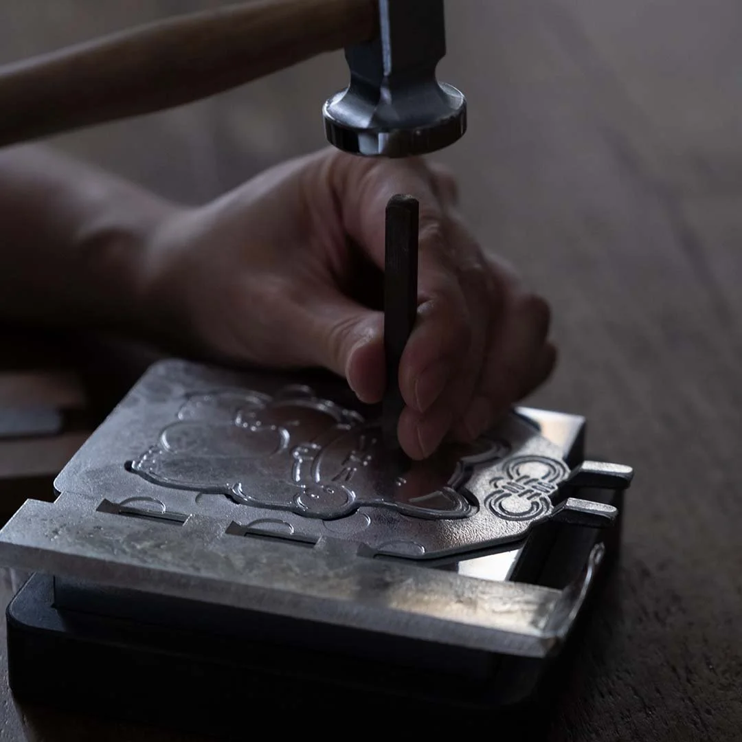 a man crafting meow cat stand with a nail and hammer on wooden table