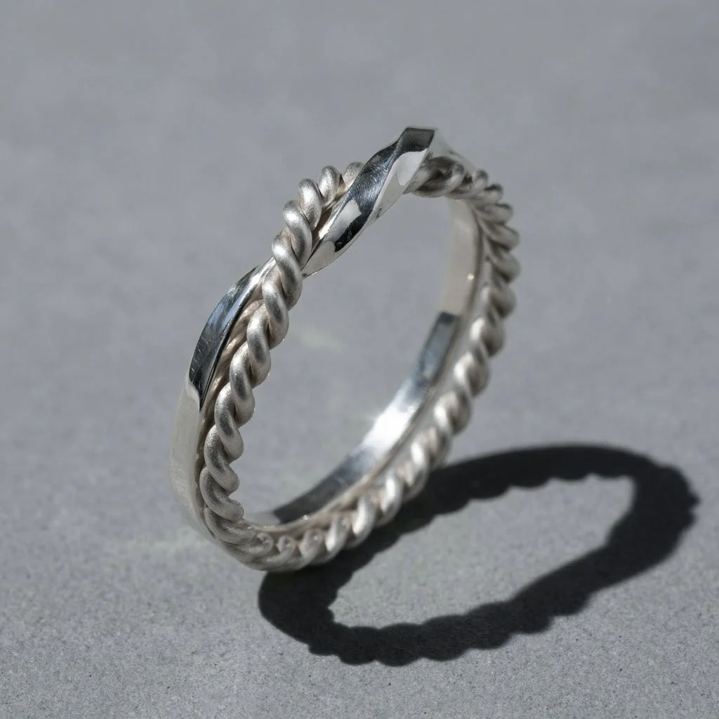 Close-up of silver Twin Souls Promise Ring on a silver surface