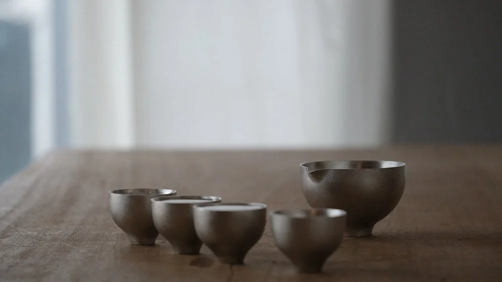 A few pure tin sake cup on a wooden table