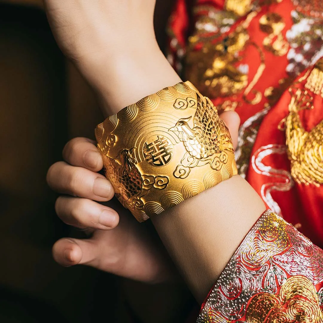 women wearing red chinese traditional gown wearing a yellow gold phoenix pattern bangle