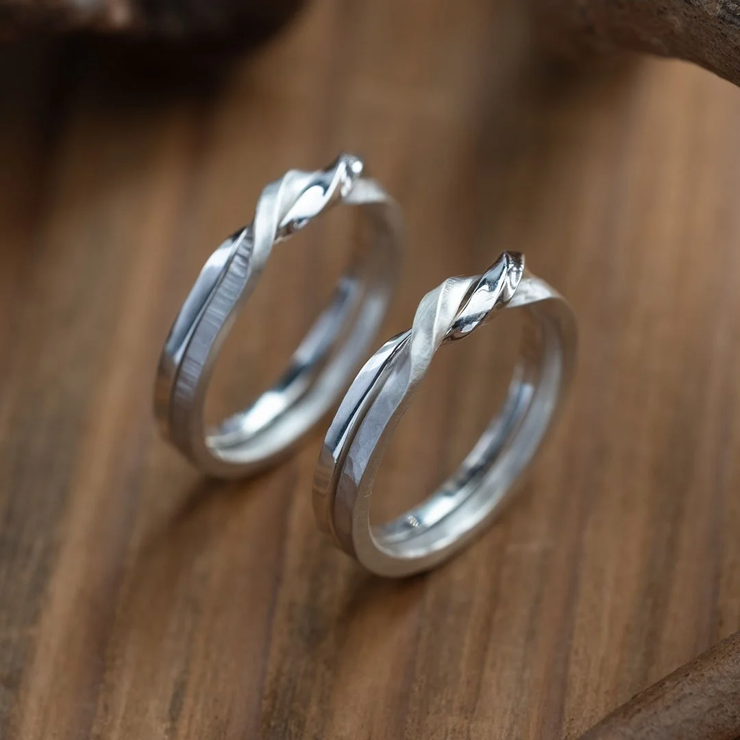 Two Sliver Twin Souls Couple Ring on wooden table