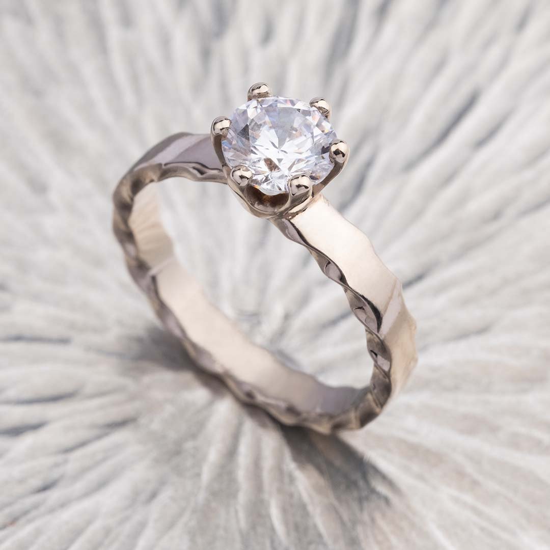 vera 200% diamond ring placed on sliver surface