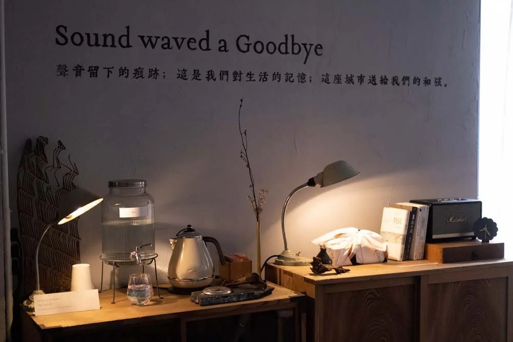 A white wall with Chinese and English wording "Sound waved a Goodbye" and quote
