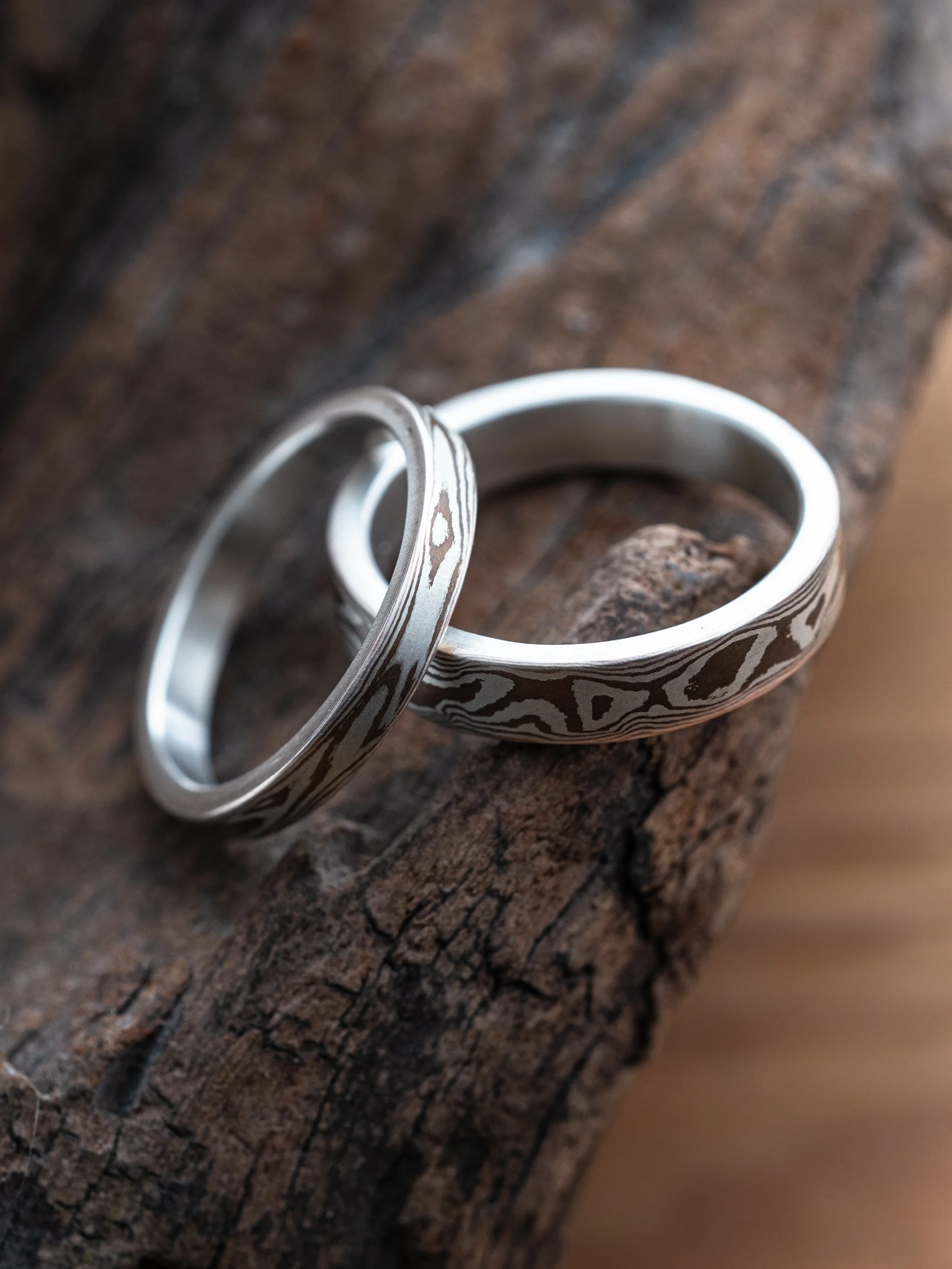 Two Perfectly Imperfect collection rings placed on a wood