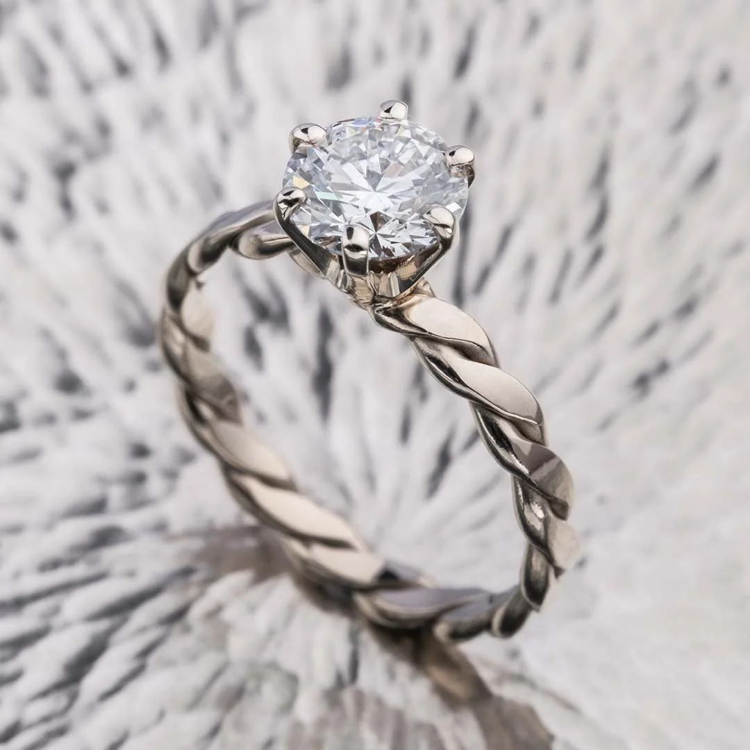 bond of us 200% diamond ring placed on sliver surface