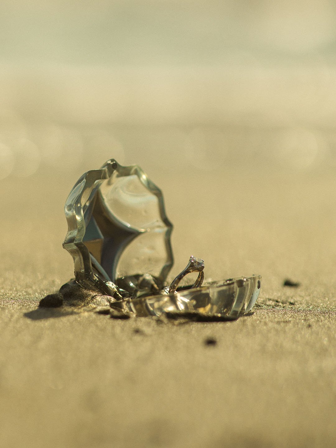 A Nova of Dream Ring Box with Love Nova Ring inside placed on the sand in a nature sun lighting