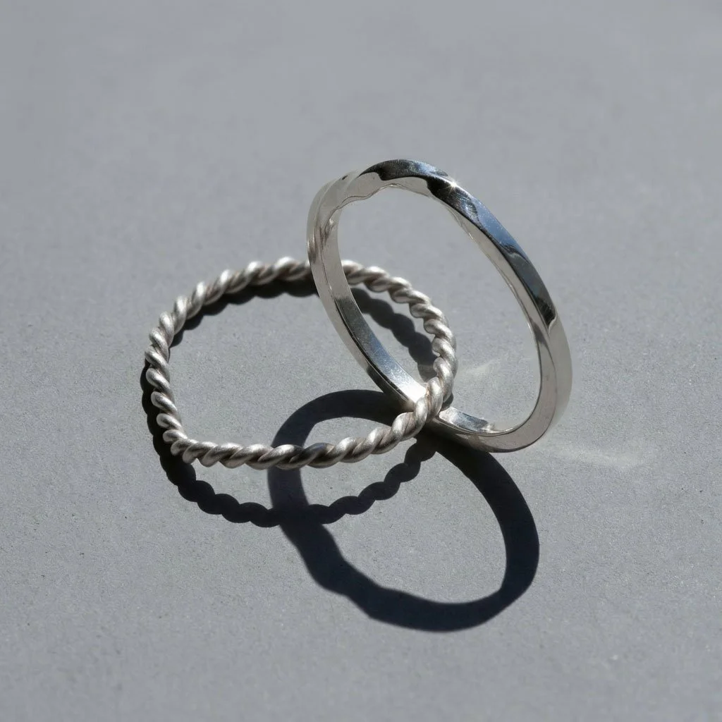 a silver Twin Souls Promise Ring on a silver surface