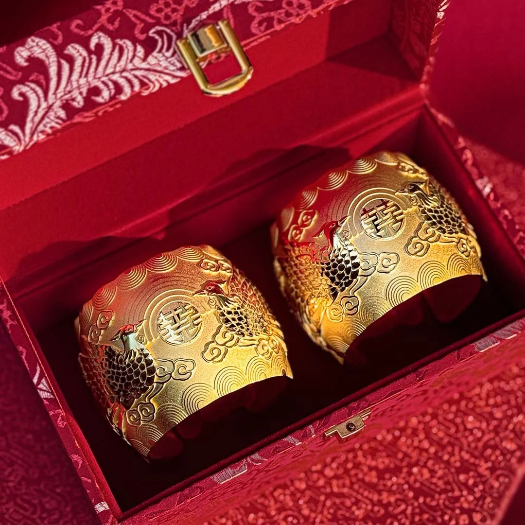 two gold phoenix bangle from Proud Pair Collection  in a red box
