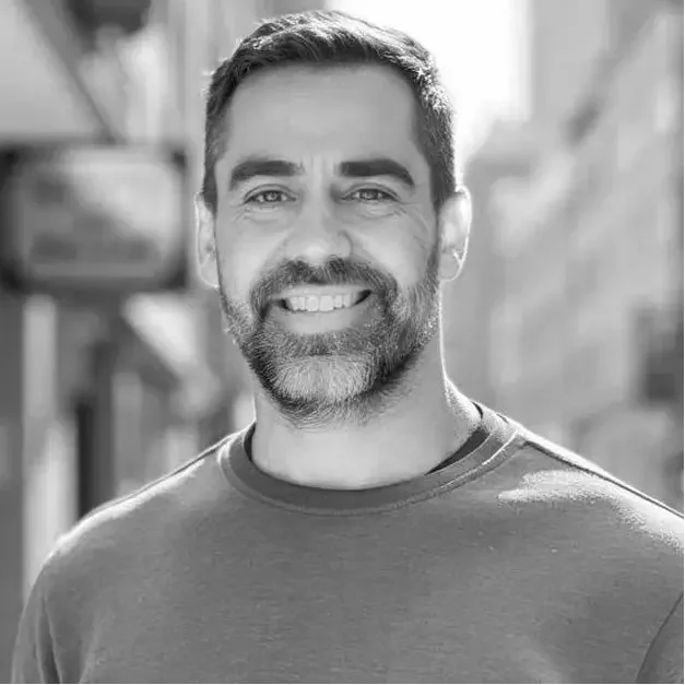 A photo of a man with a street in the background