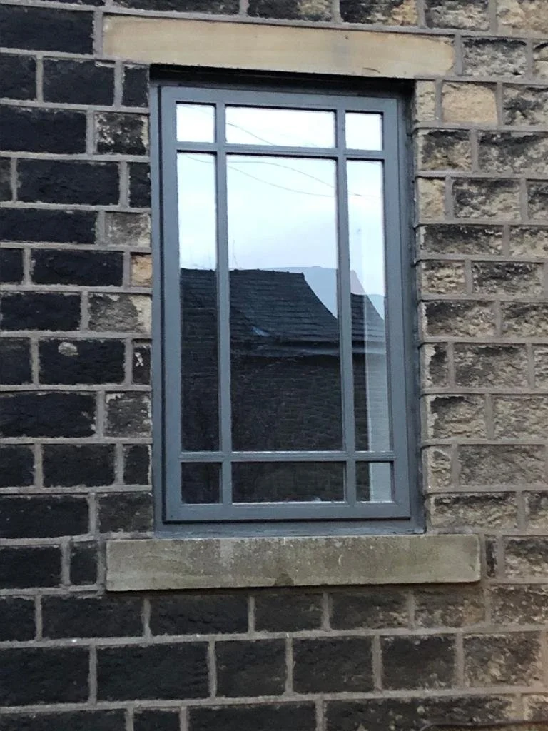 Window with gray frame on stone building