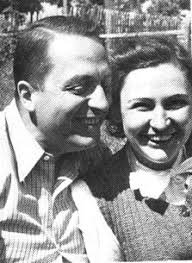 A black and white photograph of Henri Fiocca and Nancy Wake both smiling outdoors in classic attire