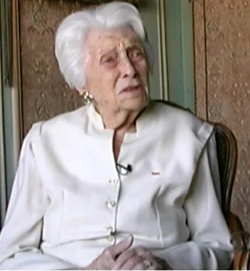 Lise de Baissac in old age, white-haired and dressed in a white suit, during her interview with Martyn Cox in her flat on the Quai de Rive Neuve, not long before her death in 2004.