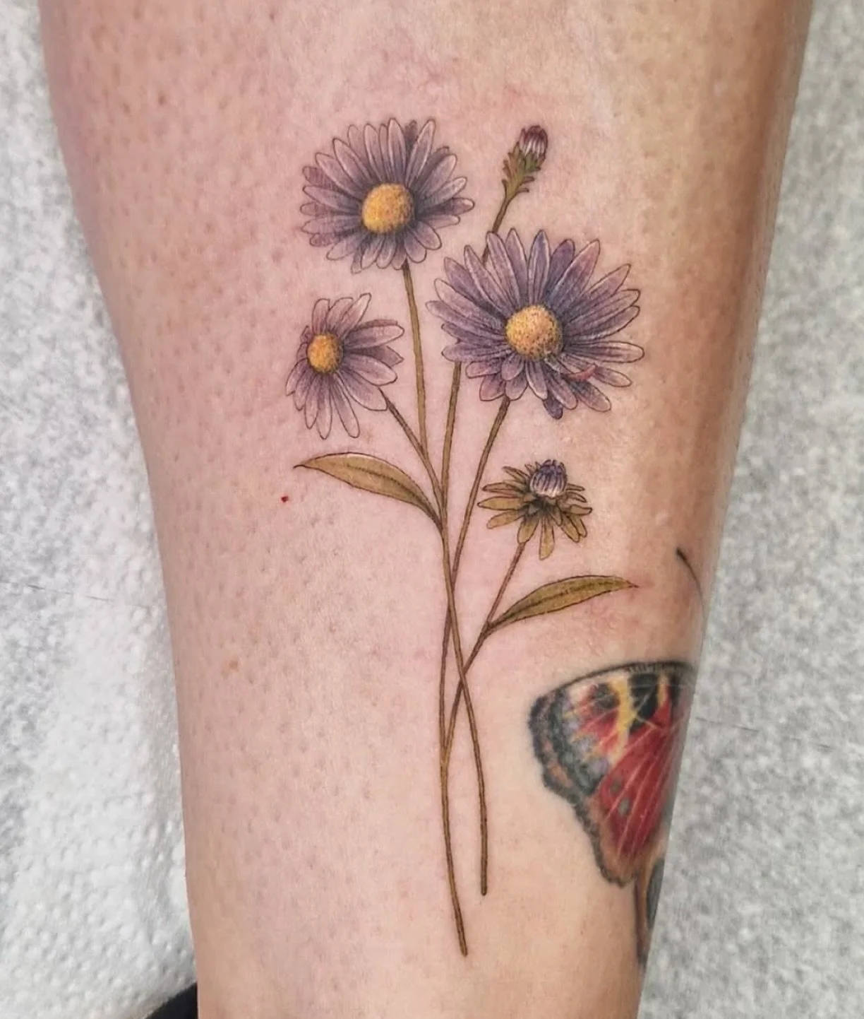 Delicate florals from @velvetgypsytattoos 
.
Heather&rsquo;s gentle touch and well-honed eye for design ensure her clients leave with beautiful works of art every time. Reach out to her directly for availability.
.
#floraltattoo #birthflowers #bright