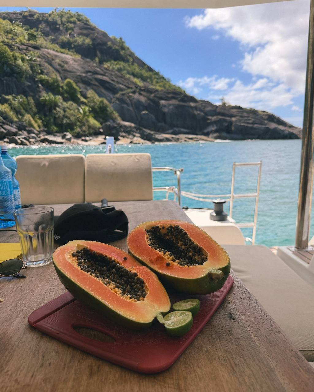 Papaya and limes on the table on catamaran in front of the island